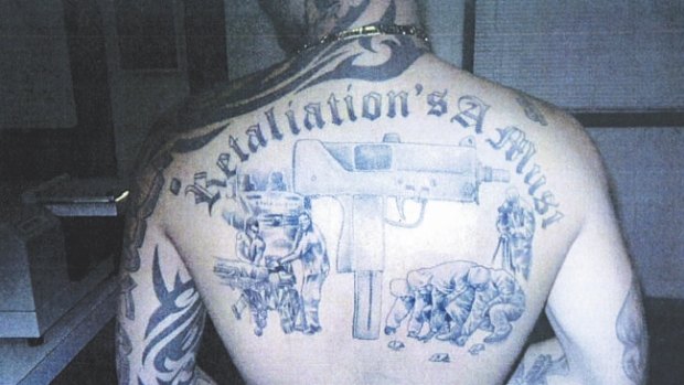 Michael Odisho's back tattoos denote his gang allegiances.
