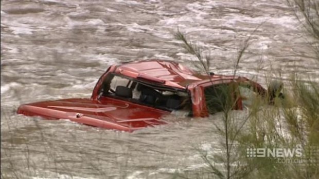 A red car in the swollen Cotter River where a 37-year-old man's body was found.