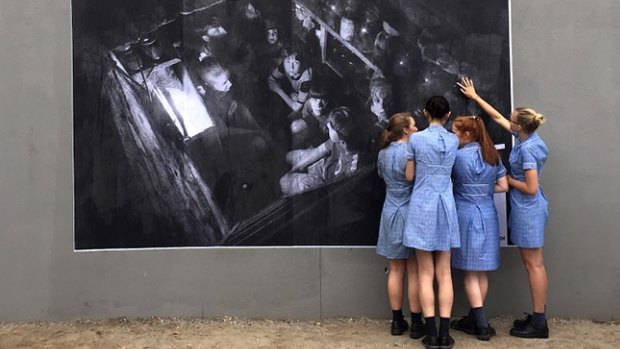 At McKinnon Secondary College, in Melbourne, the #Dysturb collective spoke with students about the power of photojournalism and the changing media landscape. Pictured is an image by Andy Rocchelli that the students helped to paste in the school. The caption reads: Ukraine, Sloviansk, Cherevkovka District. A family hides from the bombardment in the cellar.