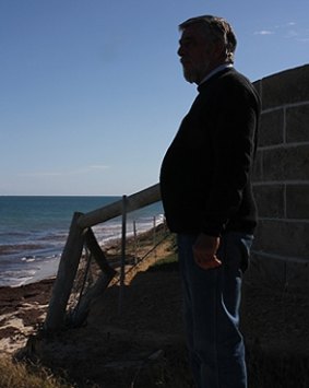 Garry Thomas at the boundary fence which is itself slipping down the dune