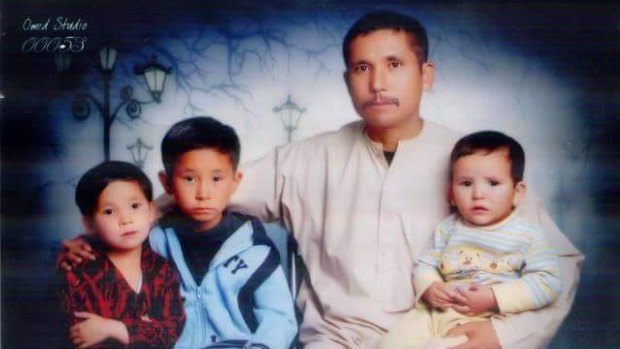 Asghar Ali with his three children, who live in Pakistan.