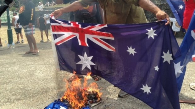 G20 protesters burn Australian flags at Musgrave Park.