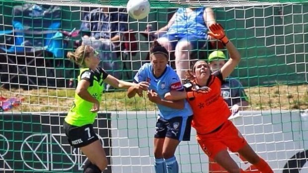Game-changer: Canberra United goalkeeper Lydia Williams is obstructed by Sydney FC striker Kyah Simon.