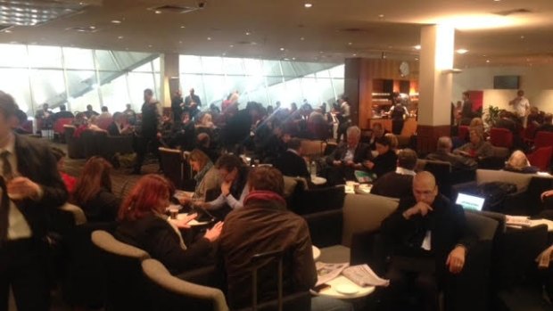 Passengers wait in the Qantas lounge at Melbourne Airport after a frost grounded flights.