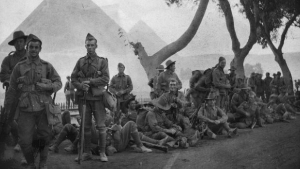  Australian Infantry resting beside the tramline near Mena, with the Giza pyramids behind them. Australian troops went to Egypt where they were sent to Mena Camp, an AIF training base, before the Gallipoli landings. 
