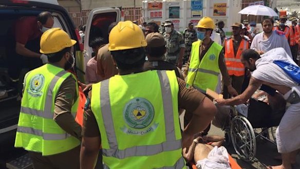Emergency workers carry patients to waiting ambulances.