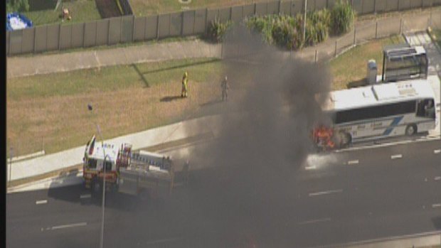 Firefighters use high-pressure hoses to control a bus fire on Anzac Avenue at Rothwell.