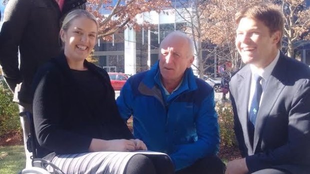 Rachael McMaster chats with Cauliflower Club chairman Mike Hogan and Canberra Rugby Business Network's Clyde Rathbone after receiving her wheelchair on Monday.