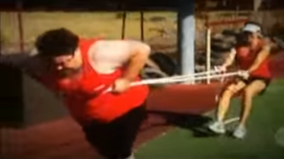 A 2012 contestant, with a rope around her stomach, tries to pull her coach in a training exercise.