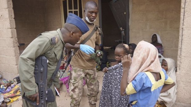 Soldiers from the Nigerian Army talk with women and children who were freed from Boko Haram, in Yola.