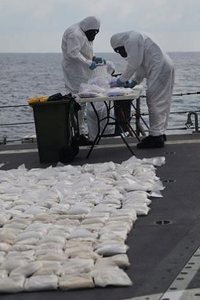 Officers process the seized drugs.