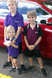 Leah children standing in front of car