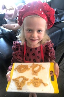 Sienna Guise, now 8, holds a tray of pasta she made during the first lockdown in New Zealand.