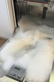A woman's dishwasher overflowed with detergent foam after using washing up liquid in it.