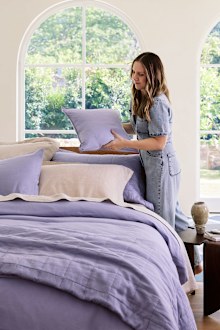 Stylist adds a blue cushion to a blue and cream bedding look.