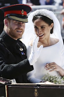 Meghan Markle reacts as she rides in a carriage with her husband Britain's Prince Harry after their wedding ceremony at St. George's Chapel in Windsor Castle in Windsor, near London, England, Saturday, May 19, 2018