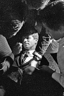 Hotel busboy Juan Romero, right, comes to the aid of Senator Robert F. Kennedy, as he lies on the floor of the Ambassador hotel in Los Angeles moments after he was shot