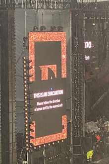 Photos from the Elton John show captured large screens ordering fans to evacuate the stadium.