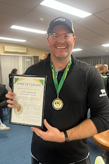 Andrew Swain posa con el premio 'Spirit of Curling'.
