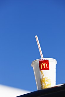 McDonalds cup sitting on ledge, blue sky in background