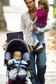Jude Law walks with Rudy in pram and Iris in North London in October 2003.