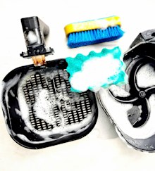 Cleaning air fryer using sponge.
