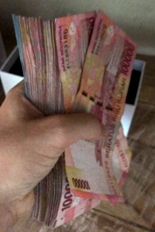 Indonesia bart, holding a wad of money notes