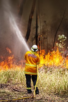 A New South Wales (NSW) Rural Fire Service volunteer douses a fire during back-burning operations in bushland near the town of Kulnura, New South Wales, Australia, on Thursday, Dec. 12, 2019. Photographer: David Gray/Bloomberg