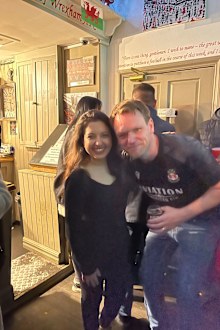 The Turf pub owner Wayne Jones celebrates Wrexham's 2-1 win over Colchester on December 16, 2023 with Karishma Sarkari