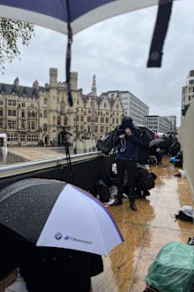 Journalists and photographers on the rained out QEII stand opposite Westminster Abbey for the coronation