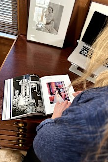 Camera Press owner and co-director Emma Blau flips through pages of the photo book Queen Elizabeth II: A Photographic Portrait by Thames & Hudson