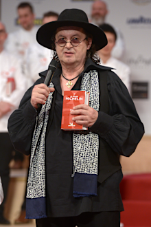 French chef Marc Veyrat holds a Michelin Guide book