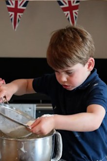 Prince Louis helps sift the flour, with great concentration