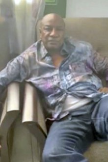 In this image made from a video released on Sunday, Guinean President Alpha Conde sits on a sofa in an unknown location.