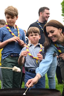 Prince George of Wales, Prince Louis of Wales and Catherine, Princess of Wales toast marshmallows as they take part in the Big Help Out, during a visit to the 3rd Upton Scouts Hut in Slough on May 8, 2023