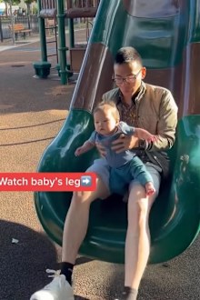 Dad going down slide with baby. 
