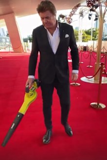 Richard Wilkins vacuums the red carpet at the 2022 Logies.