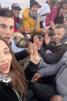 Chaima Ben Mahmoude, Ben Mahmoude (left) and her fiancé pose with others on a boat as they cross the Mediterranean on their way to Europe.