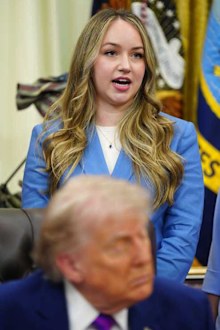 Donald Trump with his eyes closed as Monique Pruitt speaks behind him.