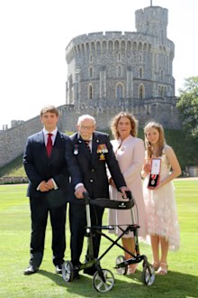 Captain Sir Thomas Moore poses with his family after being awarded with the insignia of Knight Bachelor by Queen Elizabeth II at Windsor Castle on July 17, 2020 in Windsor, England.