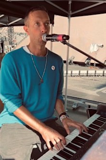 Chris Martin playing the Neighbours theme song while in Australia
