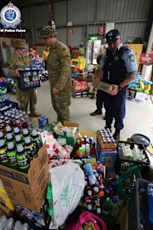 Officers from South Coast Police District and the Australian Defence Force load supplies into trucks. The supplies were delivered to the Milton Showground to support bushfire-affected towns on the state's South Coast.