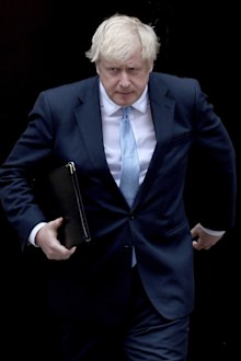 Prime Minister Boris Johnson walks towards a podium to speak to the media outside 10 Downing Street in London.