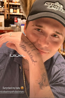 Brooklyn Beckham sitting in a bar showing off his new tattoo that says 'married'.