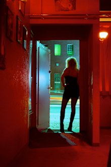 Prostitute Standing in Nightclub Doorway Looking Out