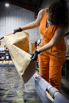 Heather Berry adds polyethylene glycol wax to a tank of
timbers as part of a conservation treatment on
shipwreck.