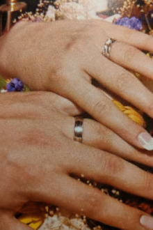 A photo of the couple wearing their rings on their wedding day.