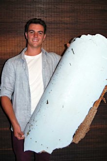 Liam Lotter poses with a piece of debris thought to be part of the missing Malaysia Airlines Flight MH370, in Wartburg. (AAP)