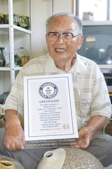 Shigemi Hirata, a 96-year-old man from Takamatsu, western Japan, poses for a photo at his home on June 3, 2016, with a Guinness World Records certificate recognising him as the world's oldest graduate. (AFP)