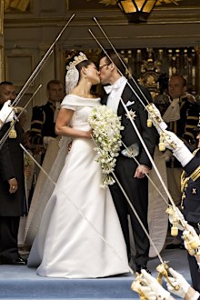 Crown Princess Victoria of Sweden and her husband Prince Daniel of Sweden kiss as they leave Storkyrkan Church.